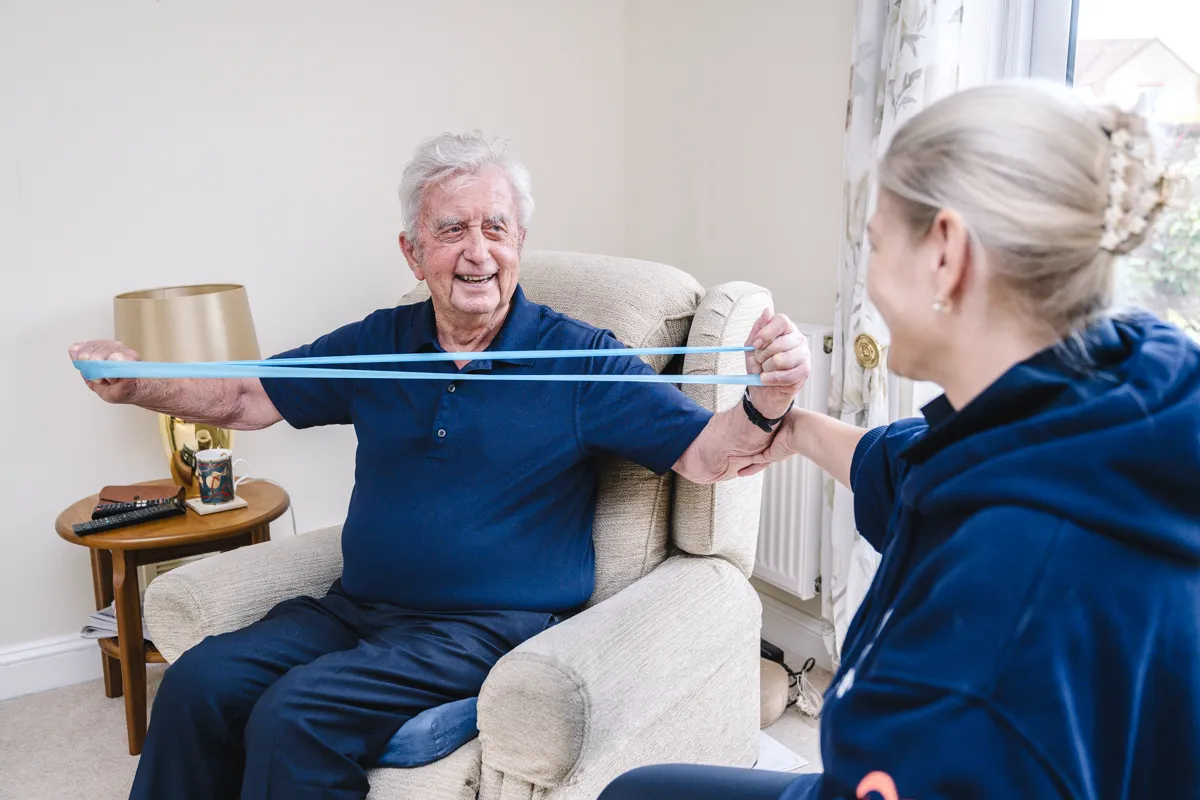 An Abney & Baker carer helping a client with strength exercises at home